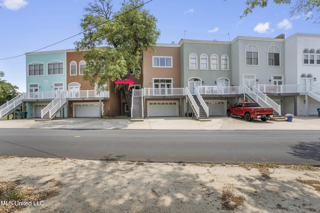 exterior space with stucco siding, driveway, stairs, and a garage