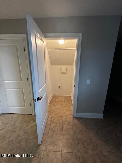 hall featuring baseboards and tile patterned floors
