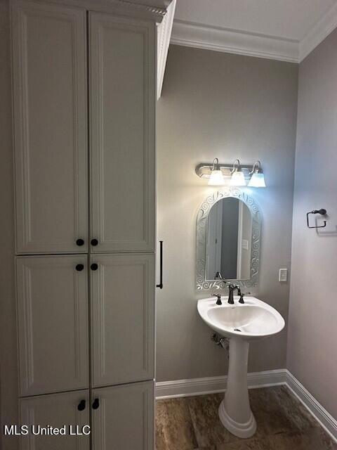 bathroom featuring crown molding and baseboards