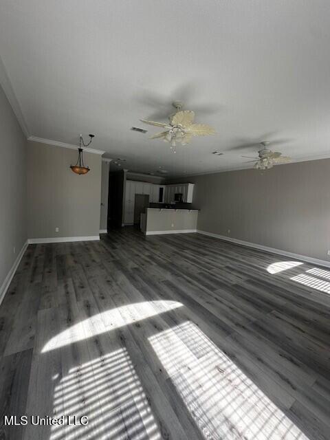 unfurnished living room featuring a ceiling fan, baseboards, ornamental molding, and wood finished floors