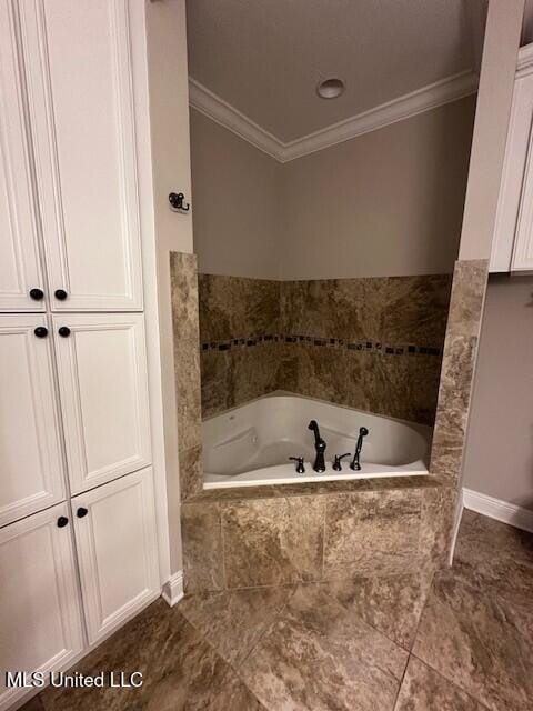 bathroom with crown molding, baseboards, and a garden tub