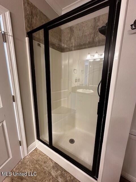 full bath with baseboards, tile patterned floors, and a shower stall