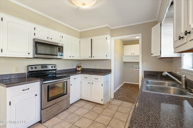 310 Lafayette St, Senatobia, MS 38668 - kitchen with crown molding, stainless steel appliances, dark countertops, white cabinets, and a sink