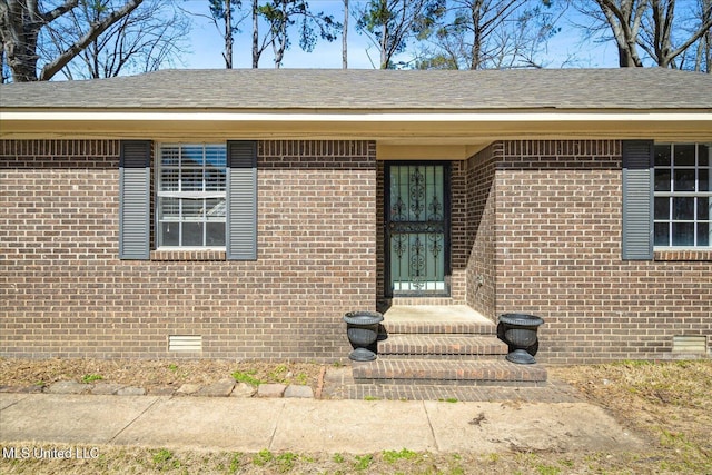 310 Lafayette St, Senatobia, MS 38668 - view of exterior entry with crawl space, roof with shingles, and brick siding