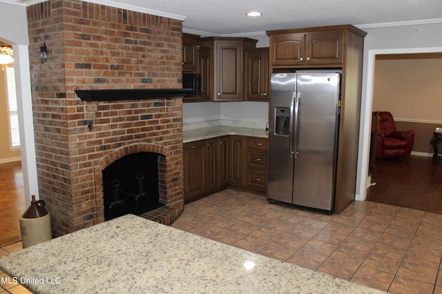 kitchen with dark brown cabinets, baseboards, ornamental molding, stainless steel refrigerator with ice dispenser, and light tile patterned floors