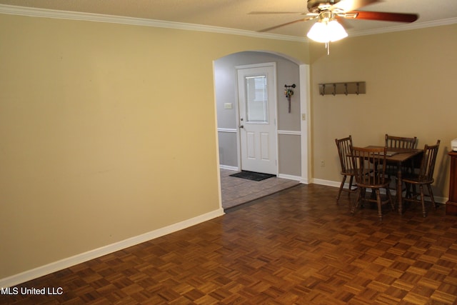 dining room with ornamental molding, baseboards, arched walkways, and ceiling fan