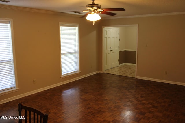 spare room with visible vents, ornamental molding, baseboards, and ceiling fan