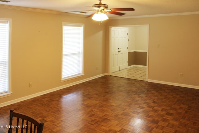 empty room with visible vents, a ceiling fan, baseboards, and crown molding