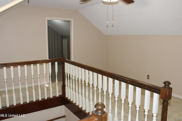 stairs with vaulted ceiling, a ceiling fan, and carpet