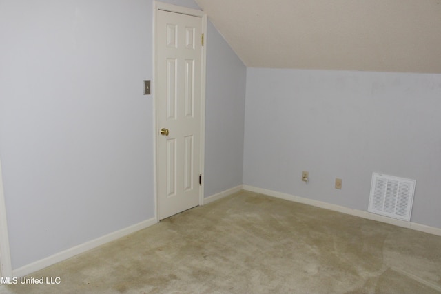 additional living space with baseboards, vaulted ceiling, visible vents, and carpet floors