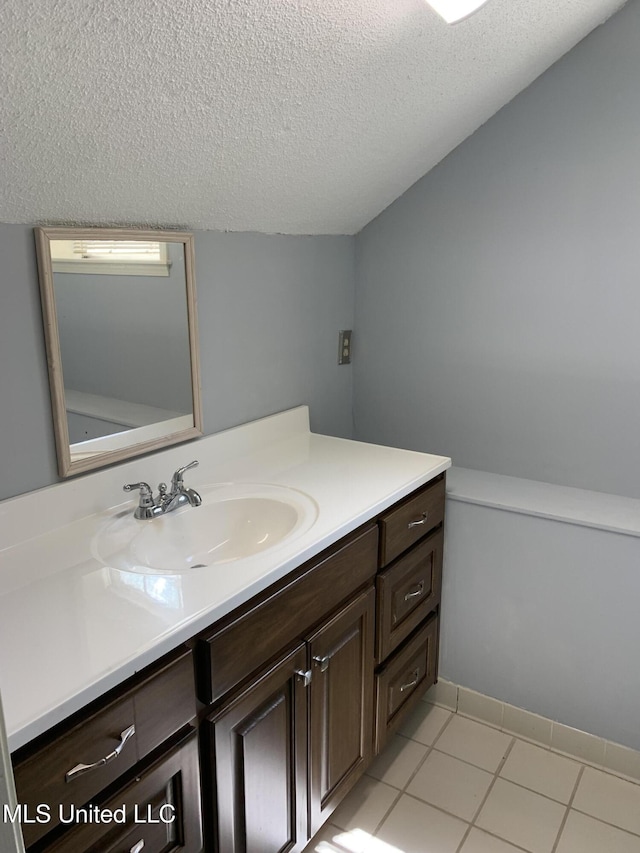 bathroom featuring tile patterned floors, vanity, and a textured ceiling