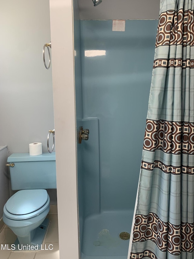 full bathroom featuring tile patterned floors, a shower with shower curtain, and toilet