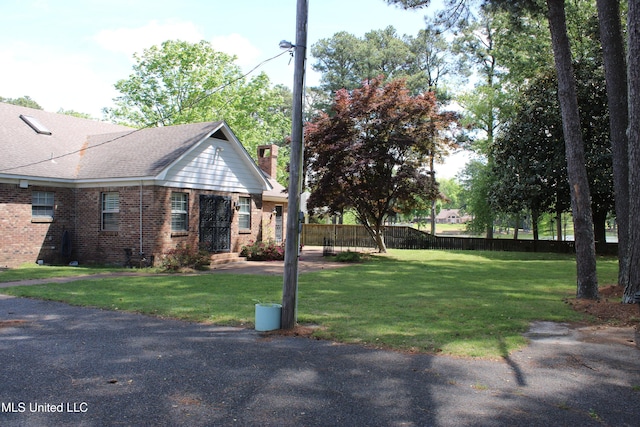 view of yard featuring entry steps and fence