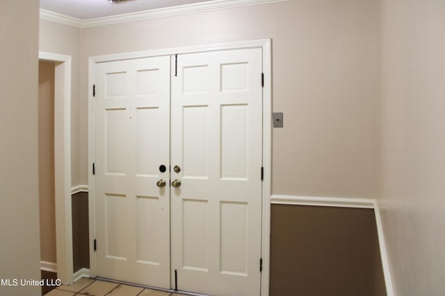 doorway featuring baseboards and crown molding