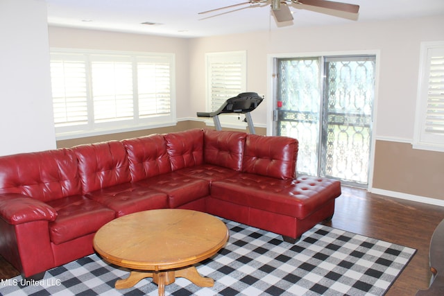 living area featuring ceiling fan, baseboards, and wood finished floors