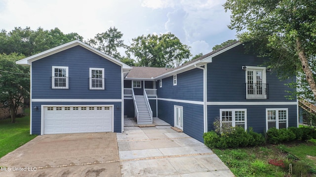 view of front of house with stairway, driveway, and a garage