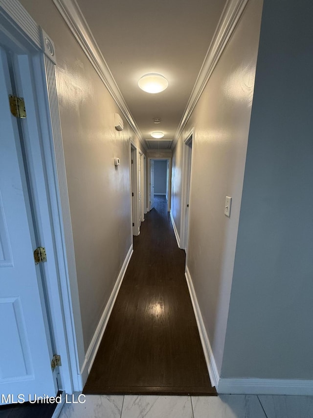 hall with crown molding, baseboards, and marble finish floor