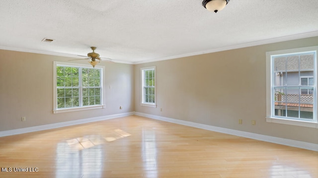 empty room featuring ornamental molding, a textured ceiling, and light wood-type flooring