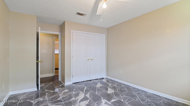 unfurnished bedroom featuring a textured ceiling, ceiling fan, and a closet