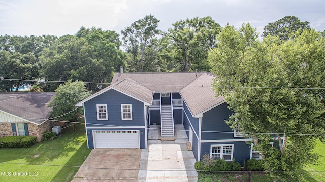 view of front of house featuring concrete driveway, a shingled roof, a front yard, and a garage