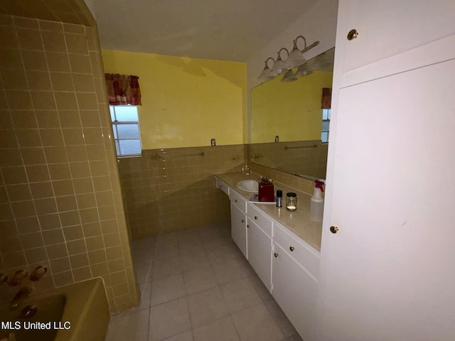 4805 Washington Ave, Gulfport, MS 39507 - bathroom featuring tile walls, tile patterned flooring, a bath, vanity, and wainscoting