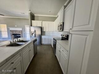 kitchen with stainless steel appliances, a sink, white cabinets, and a fireplace