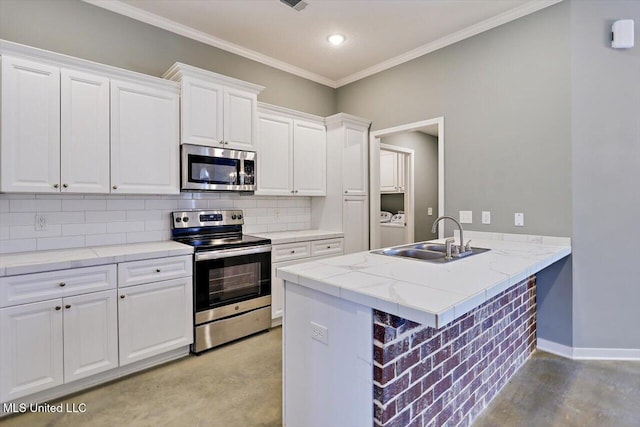 kitchen with stainless steel appliances, a sink, backsplash, a peninsula, and white cabinets