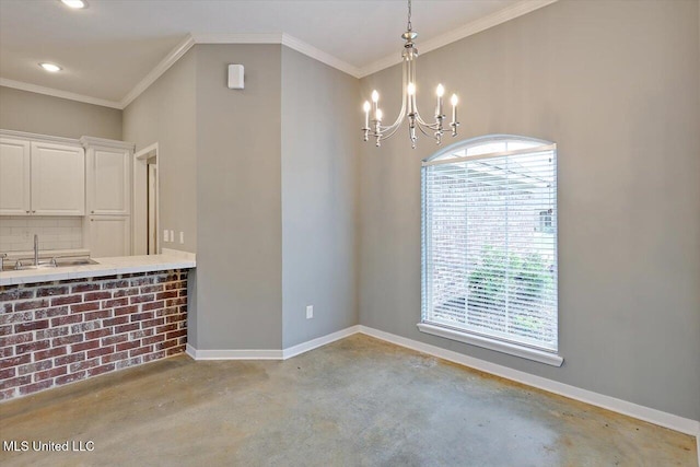 unfurnished dining area with finished concrete flooring, a sink, a chandelier, crown molding, and baseboards