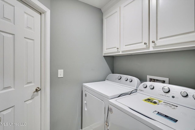 laundry area featuring washing machine and clothes dryer and cabinet space
