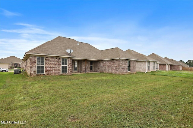 back of property featuring a lawn, brick siding, and cooling unit