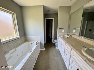 full bathroom featuring a jetted tub, a shower stall, and double vanity