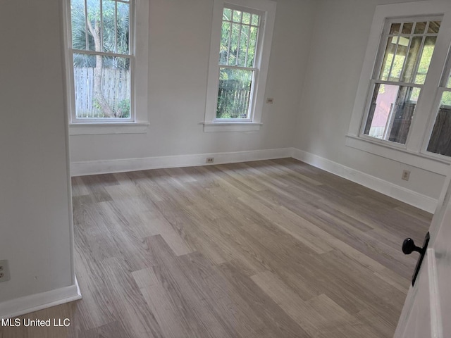 empty room with baseboards and wood finished floors