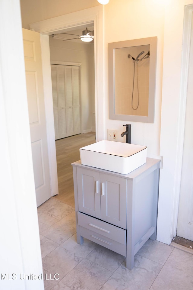 full bathroom featuring a shower, ceiling fan, and vanity