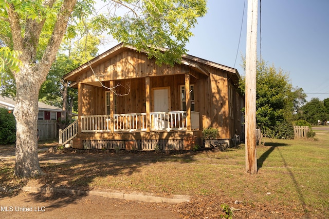 chalet / cabin with a porch and a front lawn