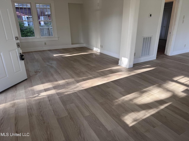 spare room featuring wood finished floors and baseboards