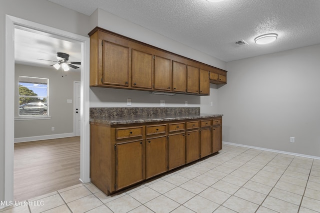 449 Klondyke Rd, Long Beach, MS 39560 - kitchen featuring brown cabinets, a ceiling fan, dark countertops, a textured ceiling, and visible vents