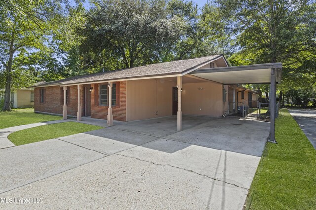 449 Klondyke Rd, Long Beach, MS 39560 - view of front of house featuring concrete driveway, a front yard, an attached carport, and roof with shingles