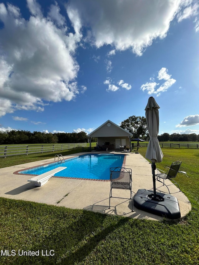 view of swimming pool featuring a diving board, a patio, and a yard