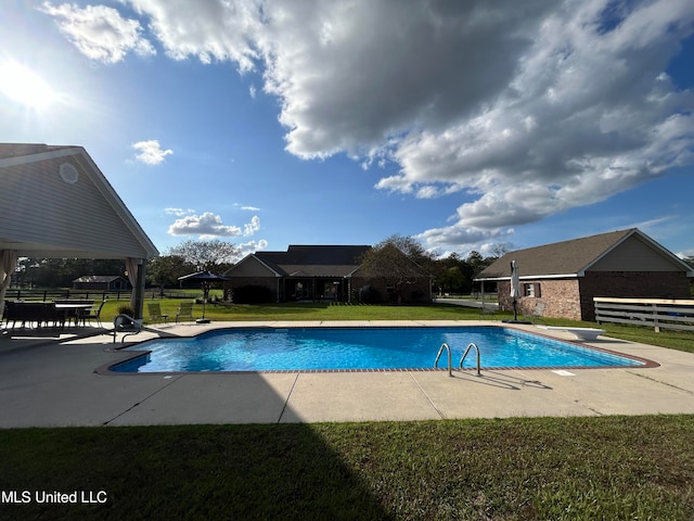 view of pool featuring a patio area, a yard, and a diving board