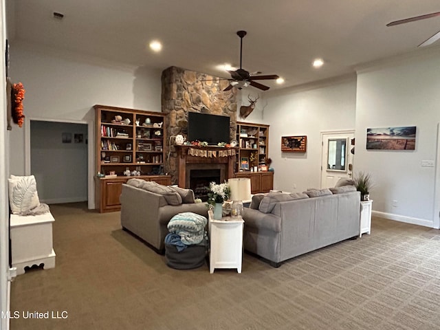 living room featuring a stone fireplace, carpet flooring, and ceiling fan