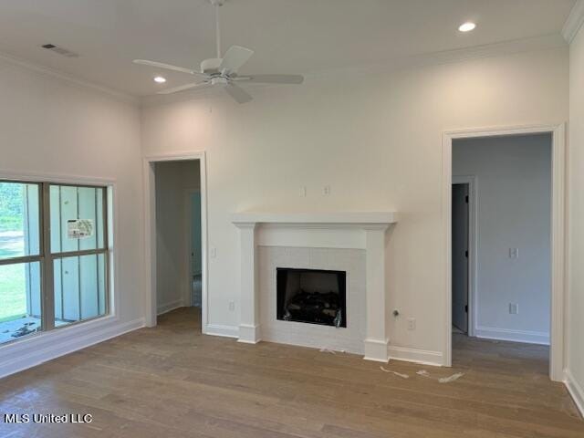 unfurnished living room featuring hardwood / wood-style floors, ceiling fan, and crown molding