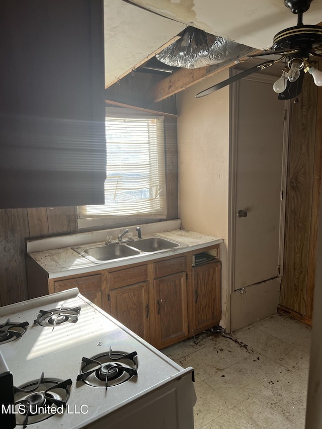 514 Lincoln Ave, Indianola, MS 38751 - kitchen featuring a sink, light countertops, a ceiling fan, light flooring, and brown cabinetry