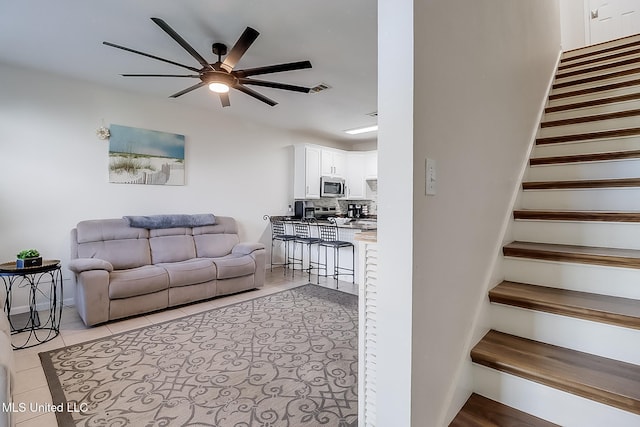 living room featuring light tile patterned floors and ceiling fan