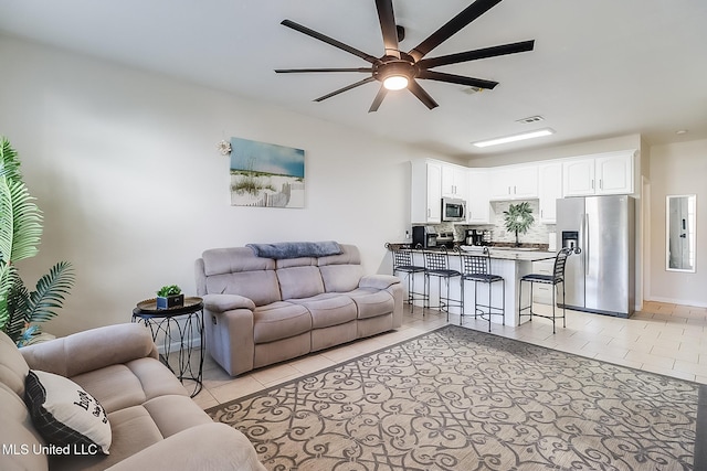 living room featuring light tile patterned floors, electric panel, and ceiling fan