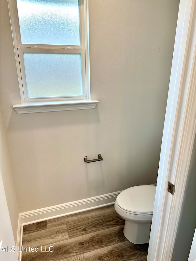 bathroom featuring hardwood / wood-style flooring and toilet