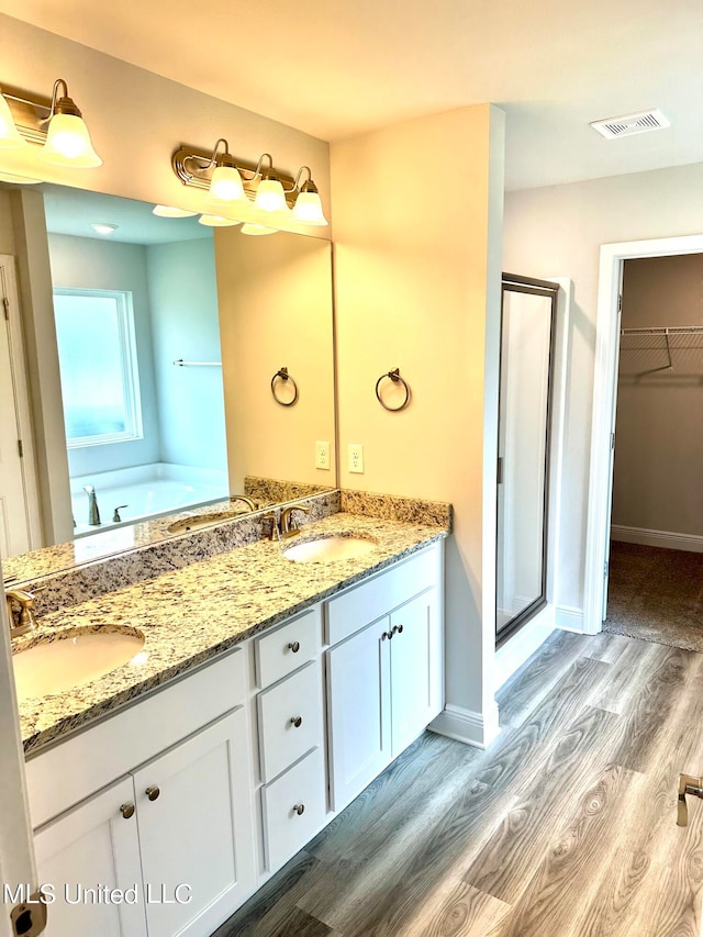 bathroom featuring hardwood / wood-style floors, vanity, and independent shower and bath