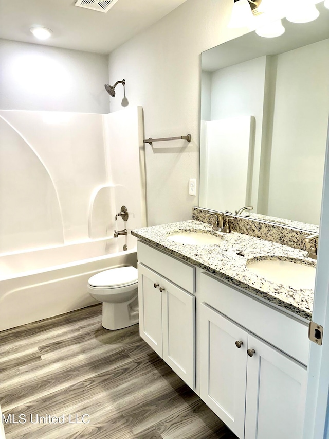 full bathroom featuring hardwood / wood-style floors, vanity, toilet, and shower / bathtub combination