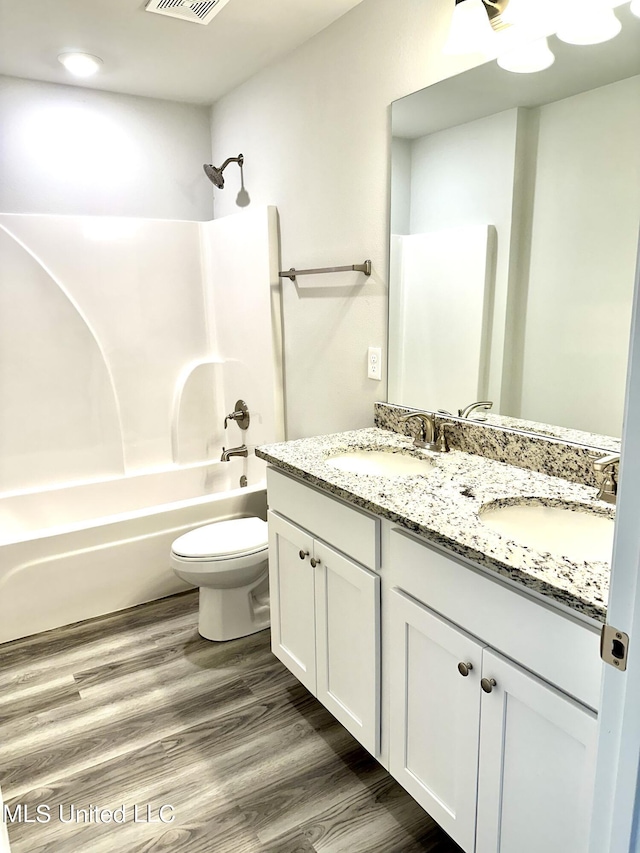 full bathroom with hardwood / wood-style floors, vanity, toilet, and shower / bathtub combination