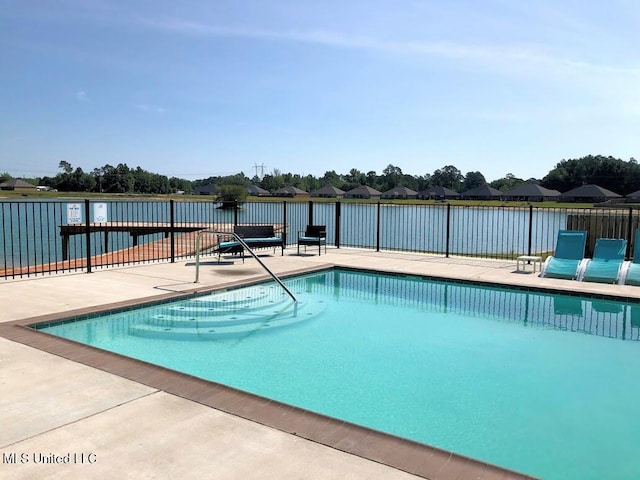 view of swimming pool with a patio and a water view