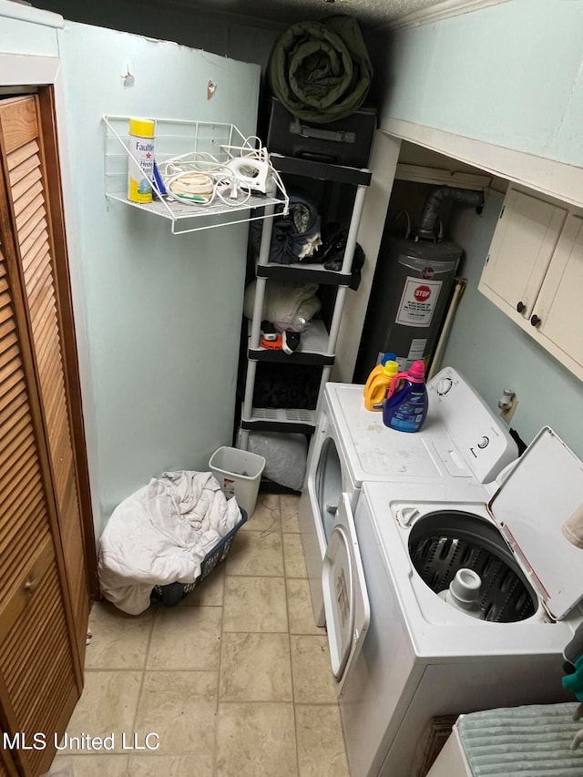 washroom featuring cabinets, water heater, separate washer and dryer, and light tile patterned floors